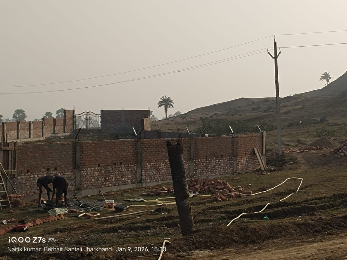 Workers constructing boundary wall at Labri BVNS School with bricks and pillars