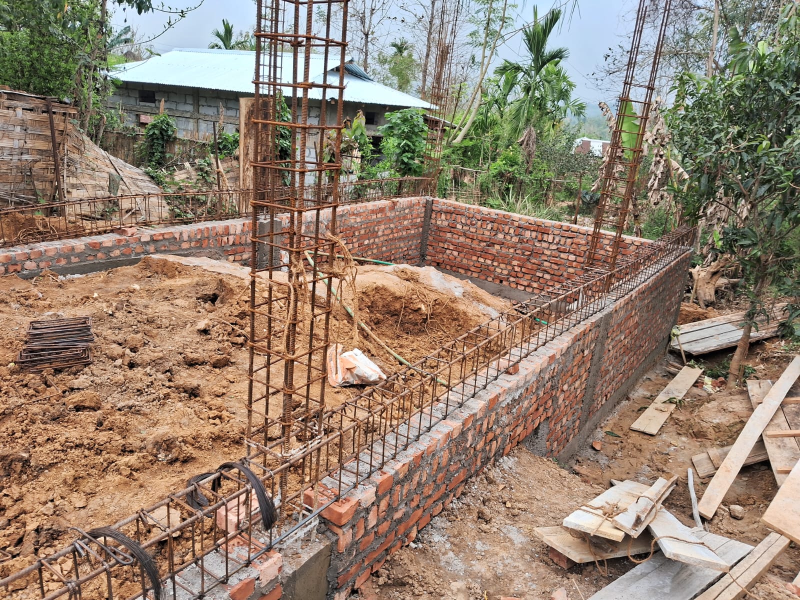 Brick walls rising with rebar columns at Langting hostel