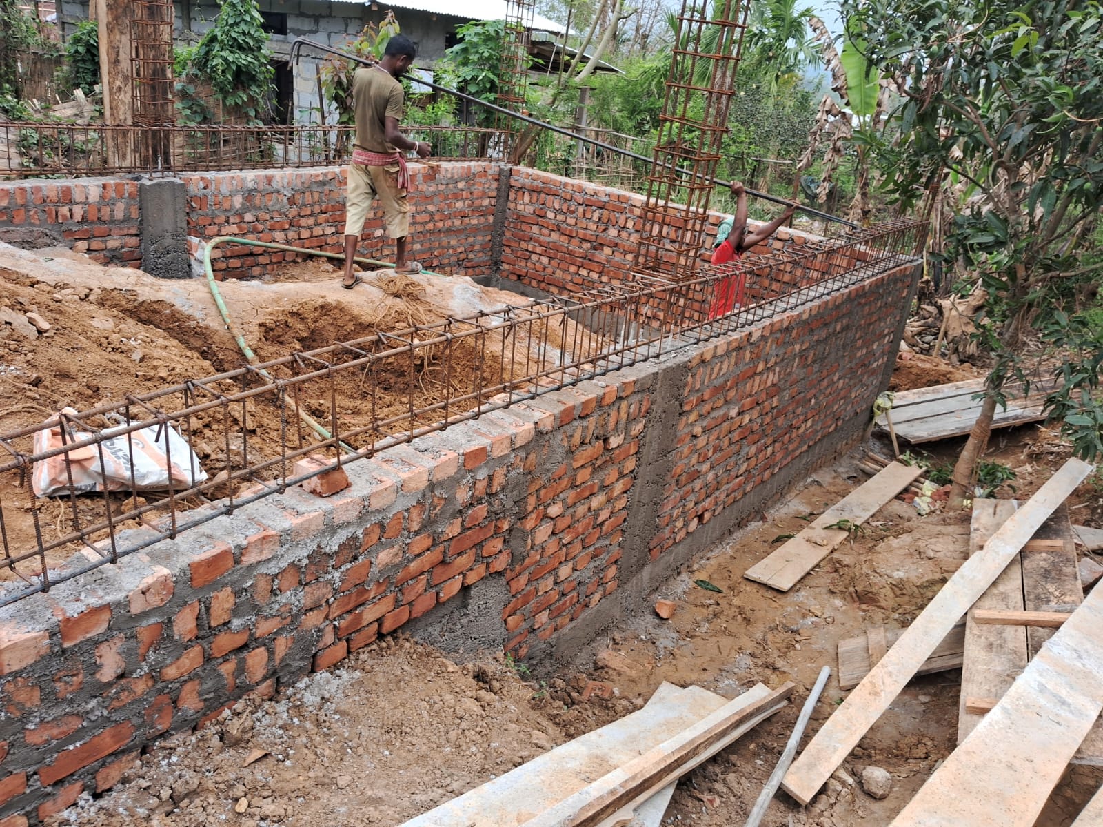Workers laying brickwork at hostel construction Langting