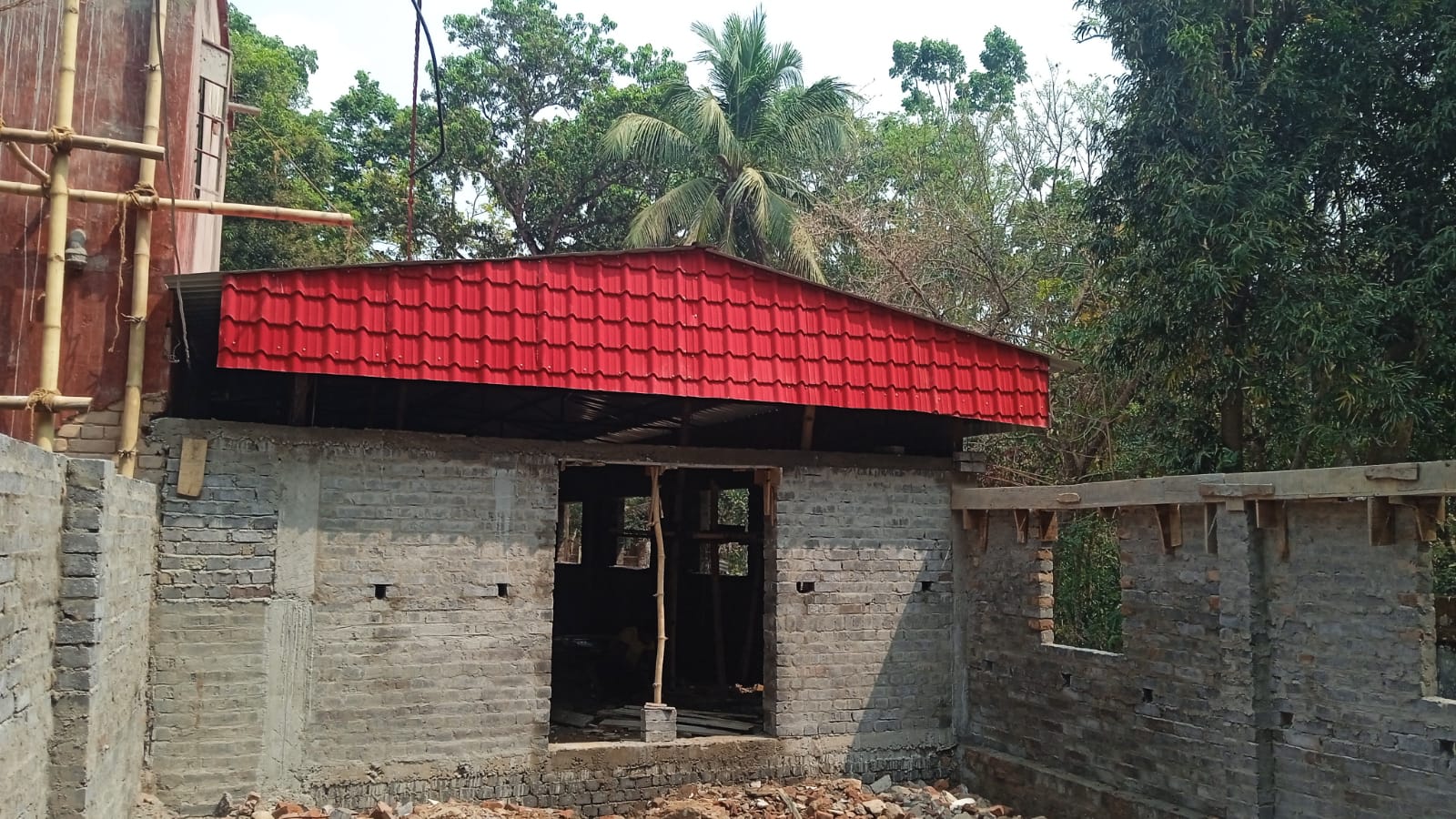 Prayer hall entrance with brick walls and red corrugated roofing