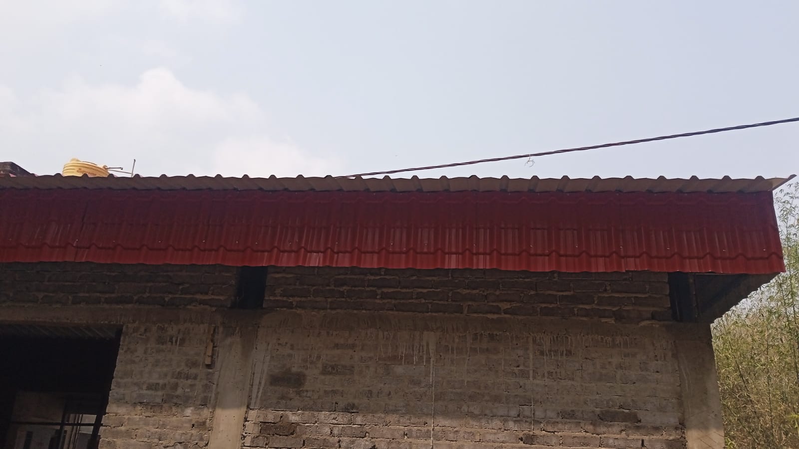 Prayer hall front view with brick walls and red roof