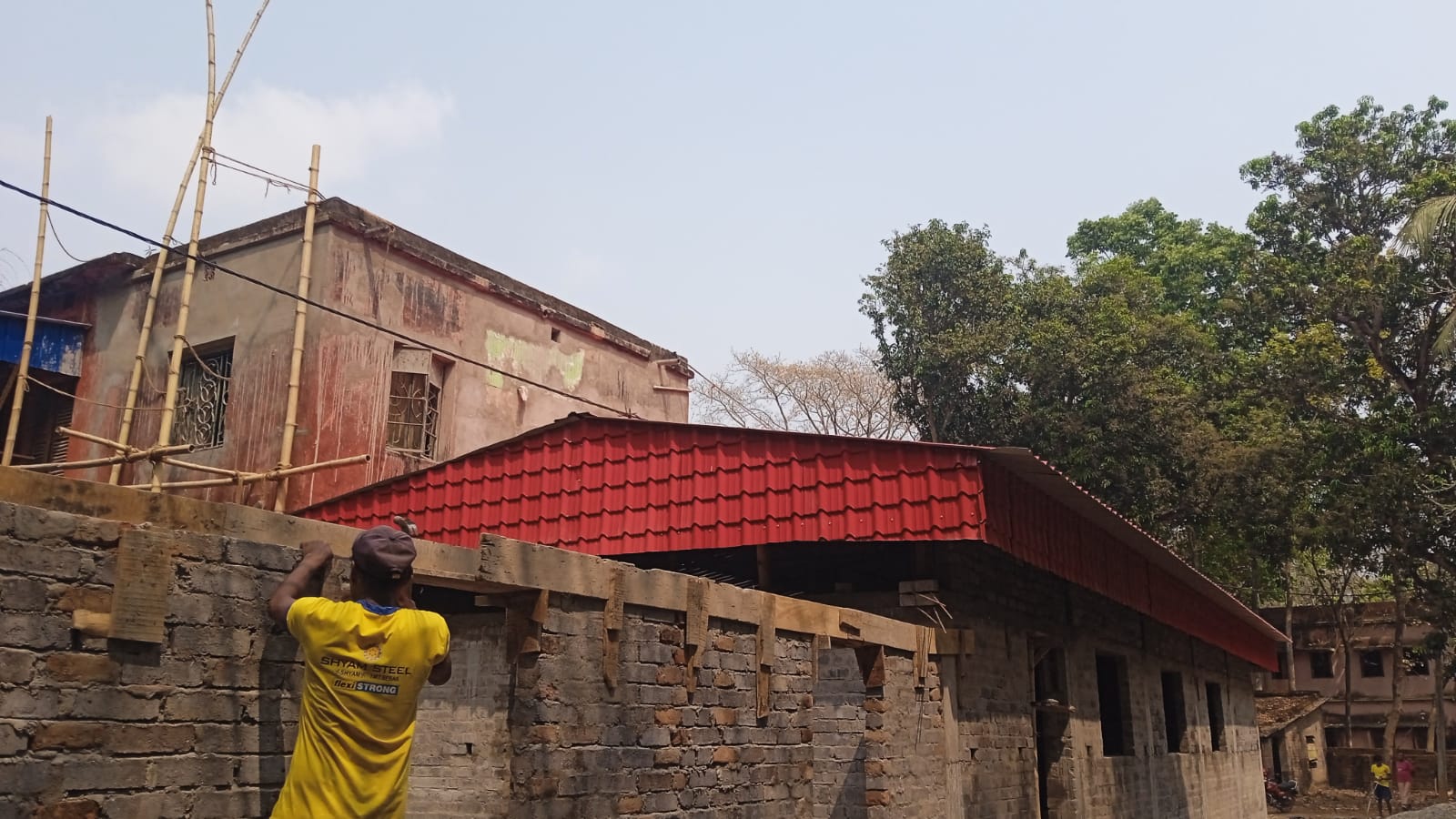 Worker laying brickwork at prayer hall construction site