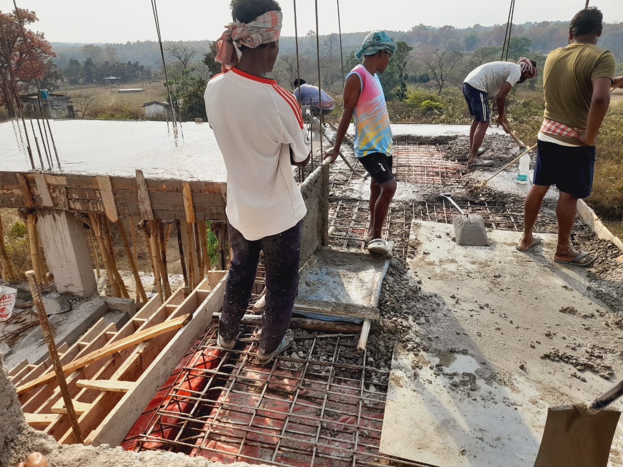 Workers pouring concrete on upper floor slab at Ayodhya Hill school