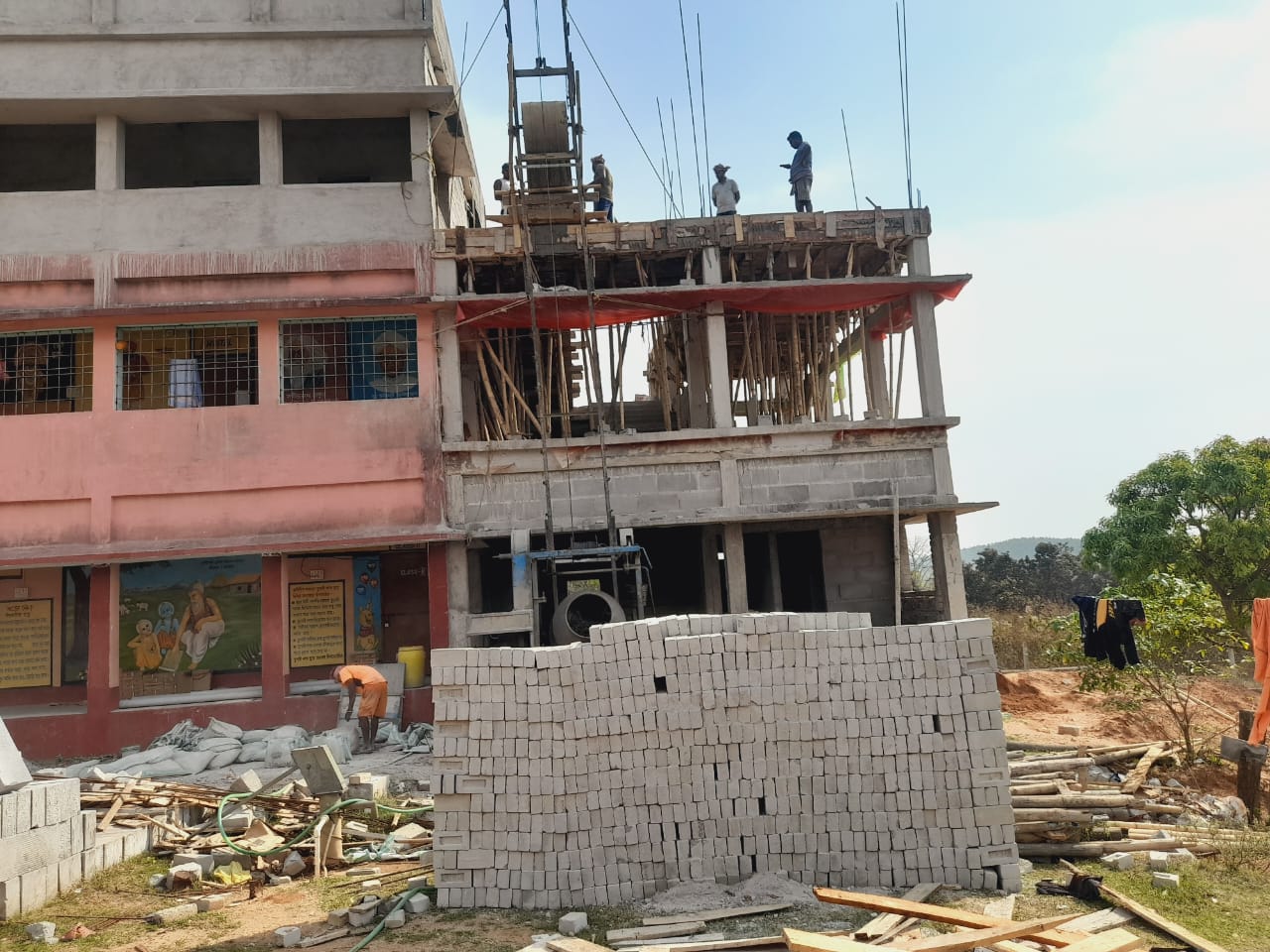 School building extension at Ayodhya Hill — scaffolding and new floors being added