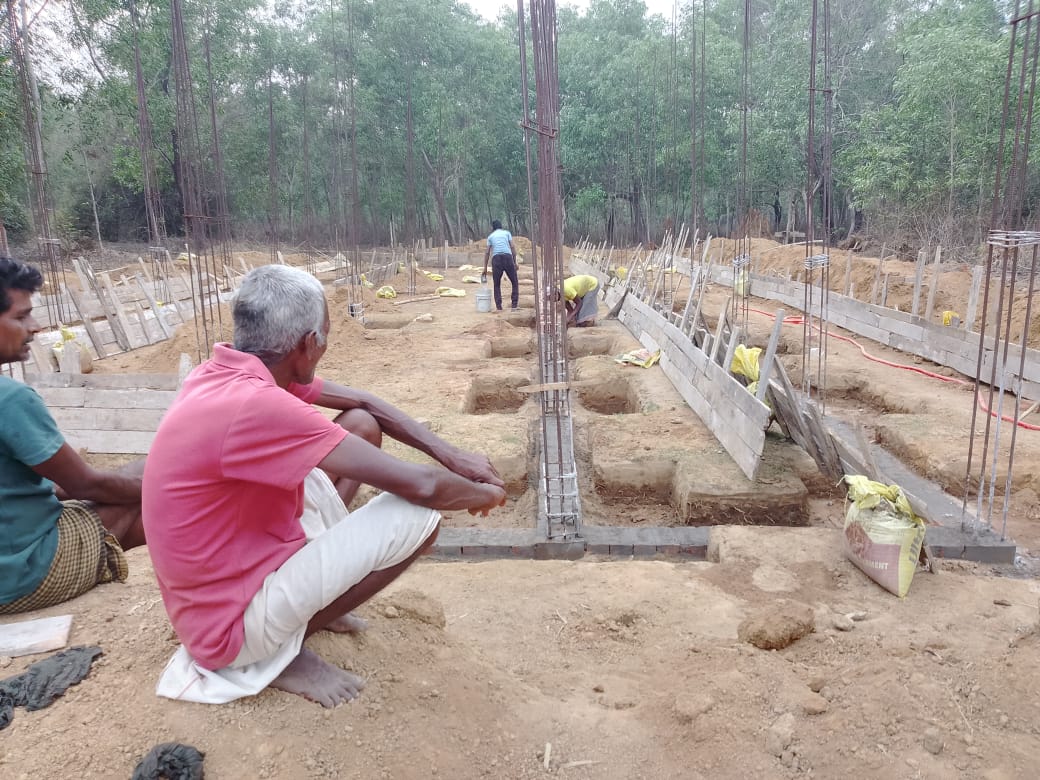 School construction at Mada Pada workers laying foundation with rebar columns