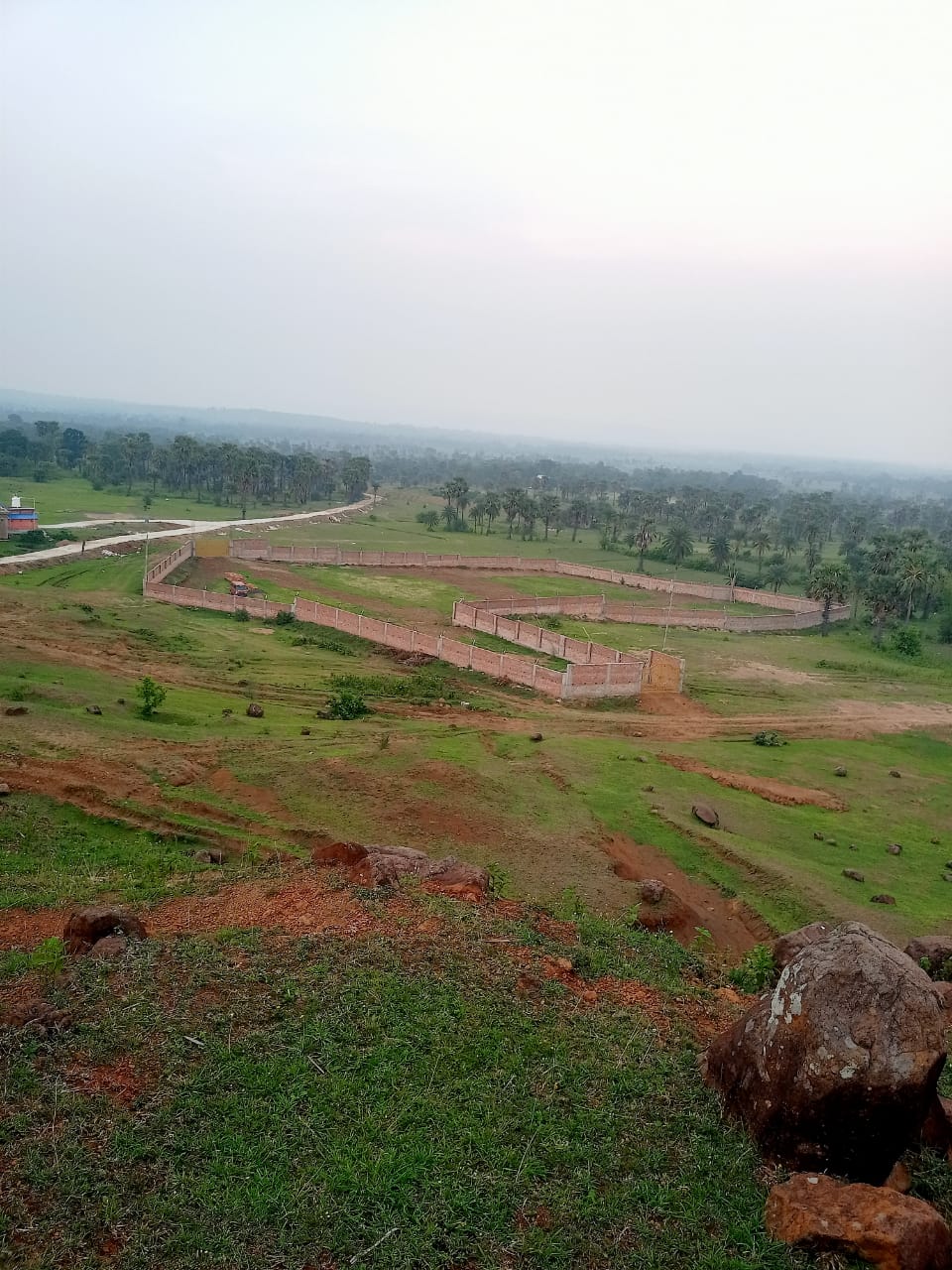 Aerial view of demarcated land plots with brick walls at Labri